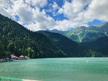 Scenic view of lake by mountains against sky