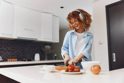 Rear view of woman using mobile phone at home