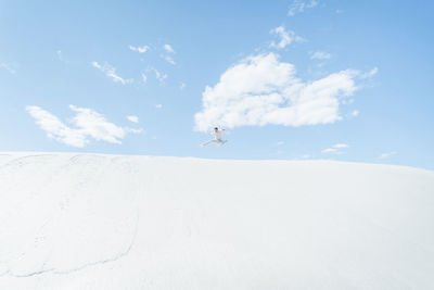 Full length of person jumping against sky