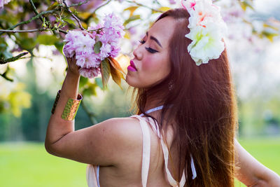 Portrait of young woman with flowers in park
