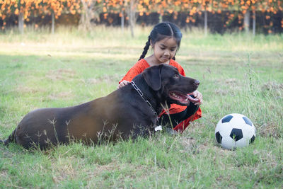 Woman with dog ball on field