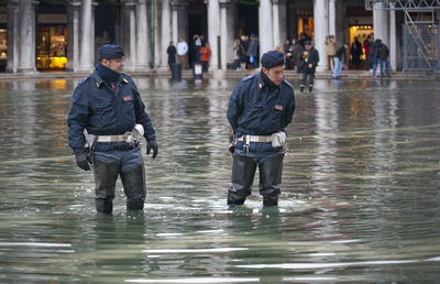 Young rescue workers standing in water filled walkway during flood