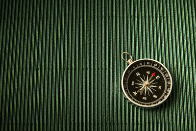 Close-up of compass on green table