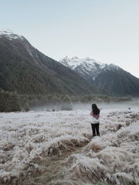 Rear view of woman standing on land