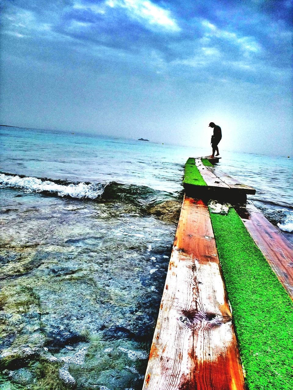 MAN IN SEA AGAINST SKY