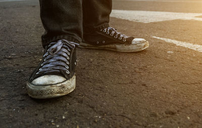 Low section of man standing on road