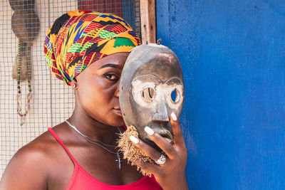 Close-up portrait of young woman against wall