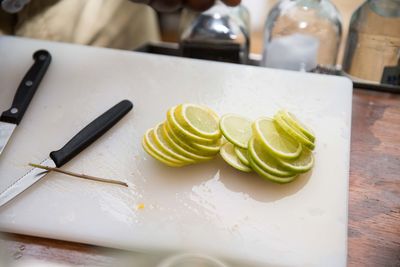 Lemon slice with knife on cutting board