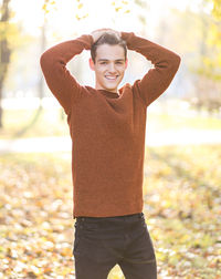 Portrait of smiling man standing in park during autumn