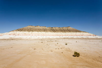 Scenic view of desert against clear blue sky