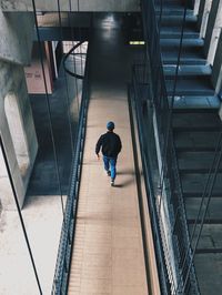 Rear view of man walking on steps