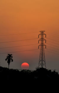 Low angle view of silhouette electricity pylon against romantic sky