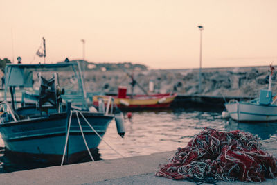 Boats moored at harbor against clear sky