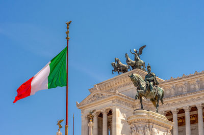 Low angle view of statues against blue sky