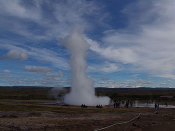 Blowhole  on landscape against cloudy sky