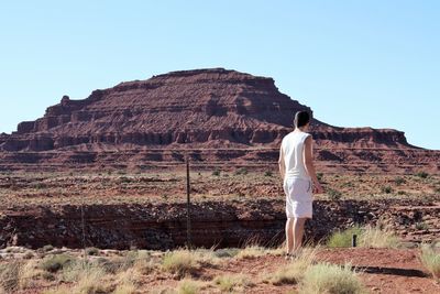 Man standing on field against mountains