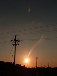 Low angle view of silhouette electricity pylon against sky during sunset