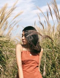 Young woman standing amidst cereal plants