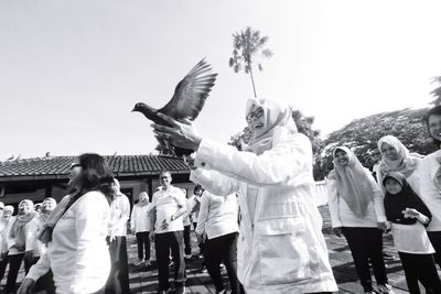 Group of people in traditional clothing against sky