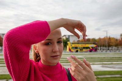 Portrait of young woman standing in city