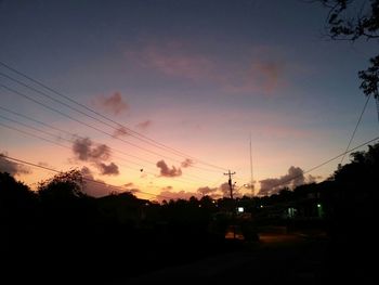 Silhouette of electricity pylon at sunset