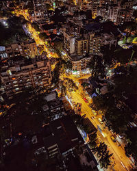 High angle view of illuminated street amidst buildings at night