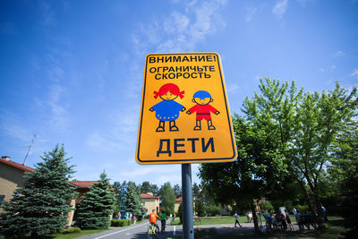 Information sign by road against sky