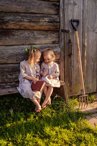 High angle view of children sitting on wooden bench