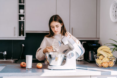 Young woman eating food at home