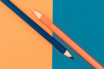 High angle view of colored pencils on table against blue wall