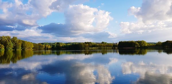 Scenic view of lake by trees against sky