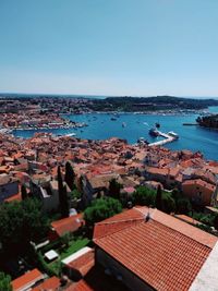 High angle view of townscape by sea against clear sky