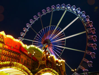 Low angle view of illuminated ferris wheel against sky at night