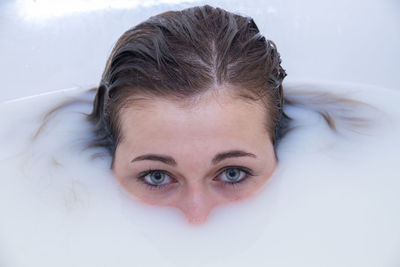 Close-up portrait of young woman in bathtub