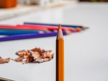 Close-up of colored pencil by table