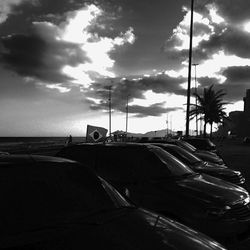 View of road by sea against cloudy sky