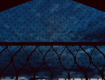 Full frame shot of metal fence against blue sky