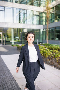 Portrait of young woman standing in city