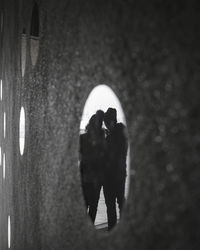 Rear view of silhouette people standing against illuminated wall