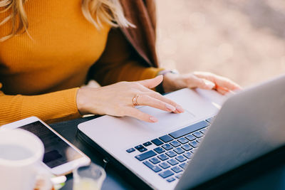 Midsection of woman using laptop