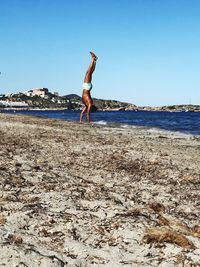 Full length of man on beach against clear sky