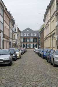 Cars on street amidst buildings against sky