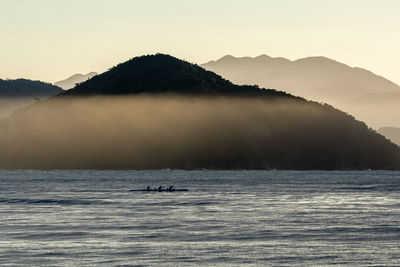 Scenic view of sea and mountains against sky