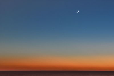 Scenic view of sea against clear sky at dusk