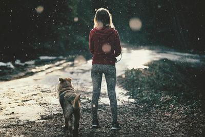 Full length of woman with dog in snow