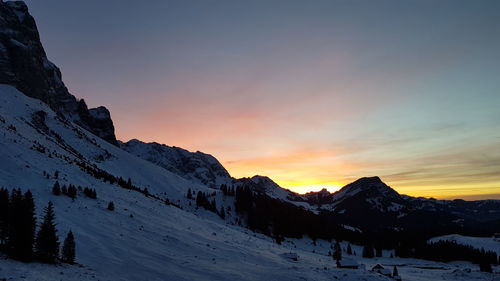 Scenic view of snowcapped mountains against sky during sunset