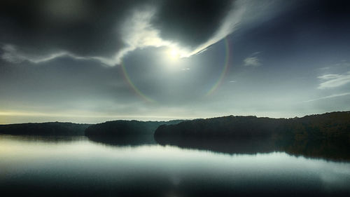 Scenic view of lake against rainbow in sky