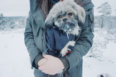 Portrait of woman with dog standing on snow