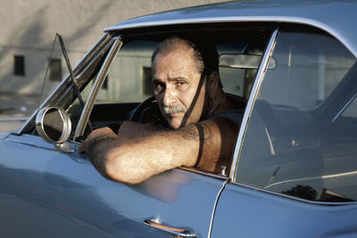 Portrait of man looking through car window