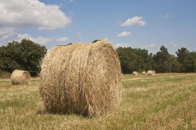 Hay bales on field against sky